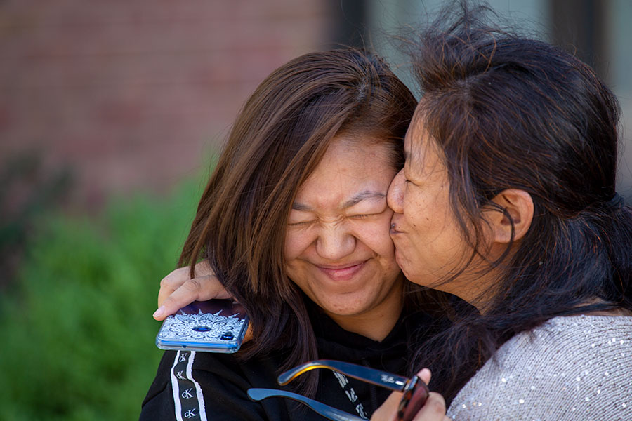 A parent embraces her daughter and kisses her on the check during new student orientation at Knox in September 2019